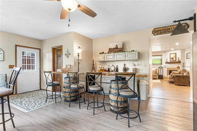 223 Horseshoe Dr, Adams Twp, PA 16046 - kitchen with light wood-type flooring, ceiling fan, and a kitchen breakfast bar