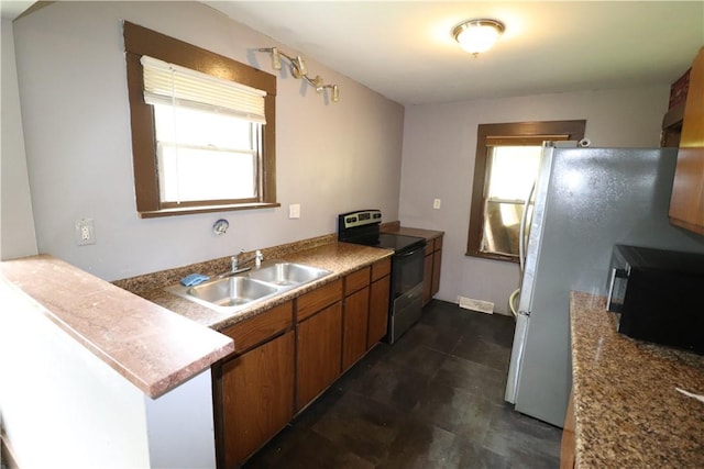 1700 Grall Ave, Shaler, PA 15209 - kitchen with range with electric stovetop, black microwave, brown cabinetry, and a peninsula