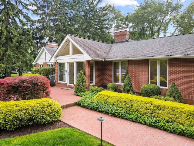 241 W Chapel Ridge Rd, Fox Chapel, PA 15238 - view of front facade with a chimney, brick siding, and roof with shingles