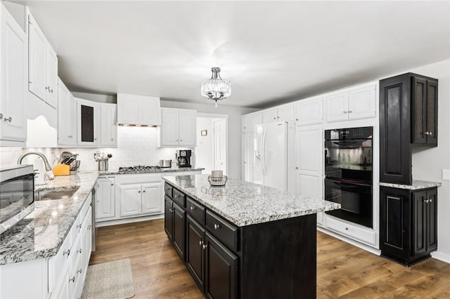 2805 Hamilton Ave, Shaler, PA 15116 - kitchen featuring appliances with stainless steel finishes, white cabinetry, dark cabinets, a chandelier, and wood finished floors