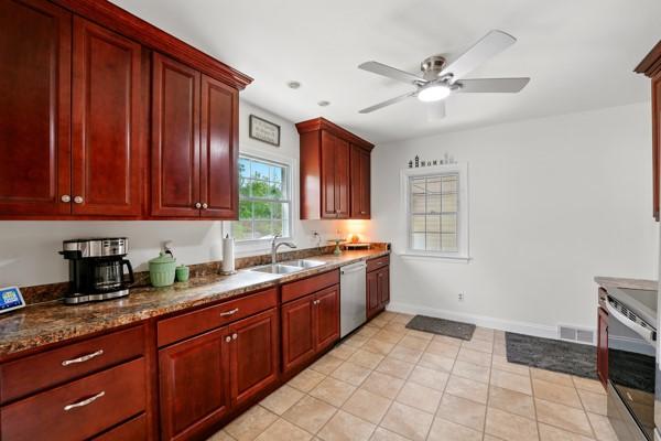 108 E Oakwood Way, Neshannock Twp, PA 16105 - kitchen with appliances with stainless steel finishes, dark brown cabinets, a ceiling fan, light tile patterned flooring, and dark stone countertops