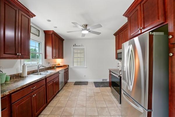 108 E Oakwood Way, Neshannock Twp, PA 16105 - kitchen with appliances with stainless steel finishes, ceiling fan, reddish brown cabinets, light tile patterned flooring, and dark countertops