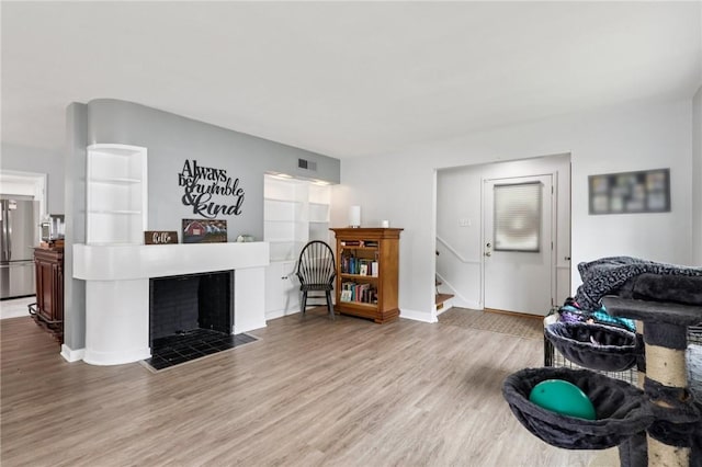 6 Edgewood Acres, Neshannock Twp, PA 16105 - living area featuring wood finished floors, a tiled fireplace, and stairs
