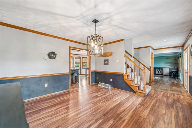 1007 Braemar Dr, Penn Twp Wml, PA 15644 - spare room with wood finished floors, stairway, crown molding, a chandelier, and a wainscoted wall