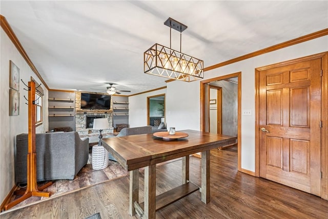 1007 Braemar Dr, Penn Twp Wml, PA 15644 - dining room featuring crown molding, a ceiling fan, dark wood-style flooring, and a fireplace