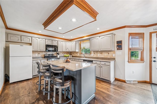 1007 Braemar Dr, Penn Twp Wml, PA 15644 - kitchen with stainless steel appliances, ornamental molding, a kitchen breakfast bar, healthy amount of natural light, and backsplash