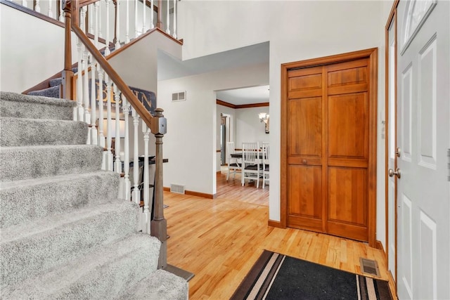 139 Village Dr, Cranberry Twp, PA 16066 - entrance foyer featuring light wood finished floors, stairs, a towering ceiling, ornamental molding, and a chandelier