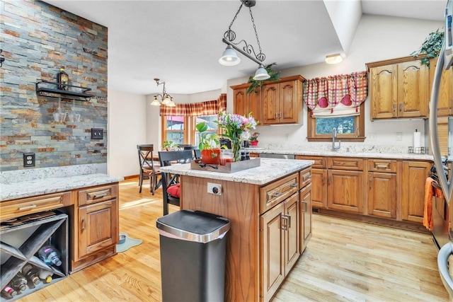 139 Village Dr, Cranberry Twp, PA 16066 - kitchen featuring hanging light fixtures, light wood finished floors, a kitchen island, and brown cabinetry
