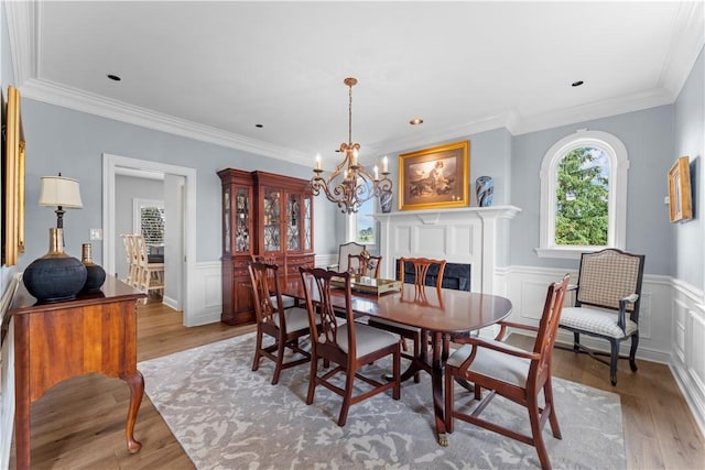 1055 Saint Mellion Dr, Collier Twp, PA 15142 - dining space with a chandelier, crown molding, light wood-type flooring, a wainscoted wall, and a decorative wall
