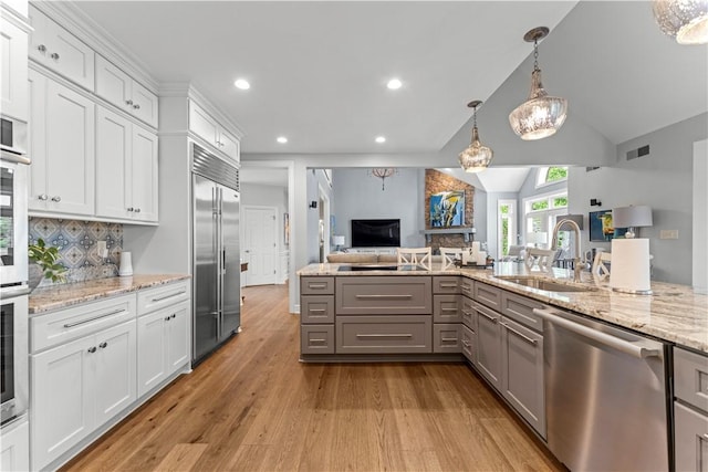1055 Saint Mellion Dr, Collier Twp, PA 15142 - kitchen with stainless steel appliances, gray cabinetry, open floor plan, light wood-style floors, and decorative backsplash