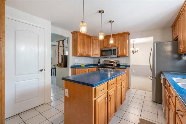 126 Penn Lear Dr, Monroeville, PA 15146 - kitchen featuring stainless steel appliances, light tile patterned floors, dark countertops, a kitchen island, and pendant lighting