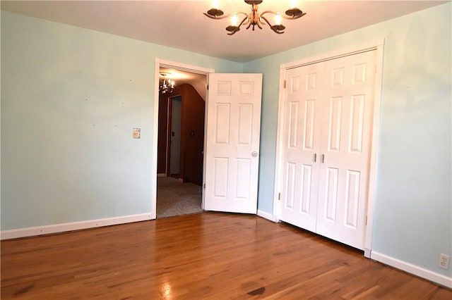 714 Colonial, Coolbaugh Twp, PA 15613 - unfurnished bedroom with a chandelier, wood finished floors, and a closet