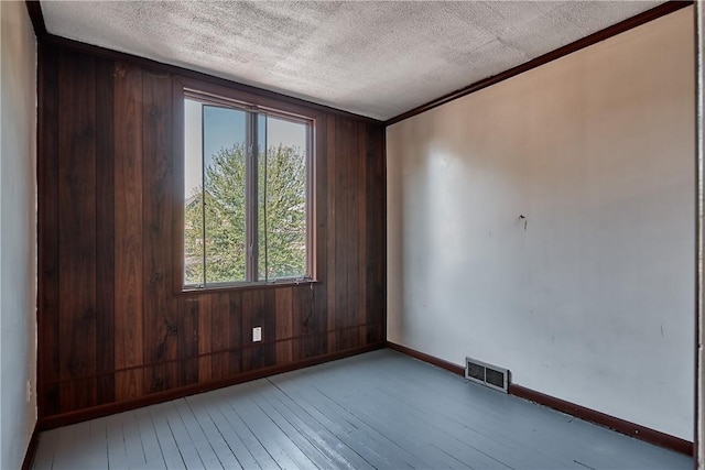 538 Maplewood Ave, Ambridge, PA 15003 - empty room featuring hardwood / wood-style flooring, a textured ceiling, wood walls, and crown molding