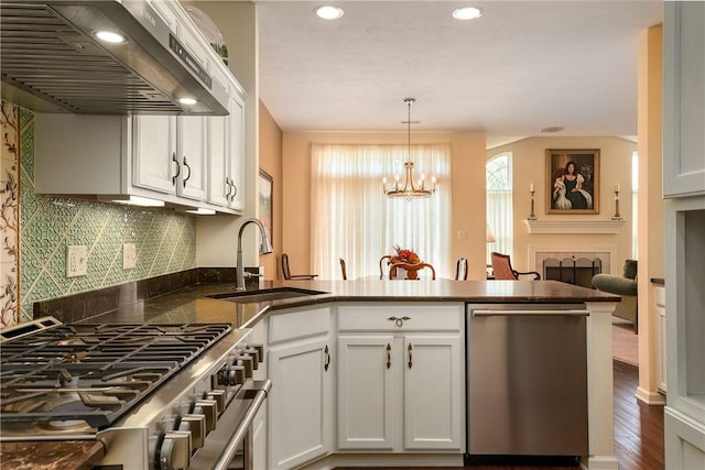 560 Madison Blvd, New Sewickley Twp, PA 15042 - kitchen featuring wall chimney range hood, stainless steel appliances, a peninsula, pendant lighting, and dark countertops