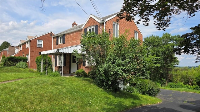 1016 Dallett Rd, Whitehall, PA 15227 - back of house featuring brick siding, a yard, and a chimney