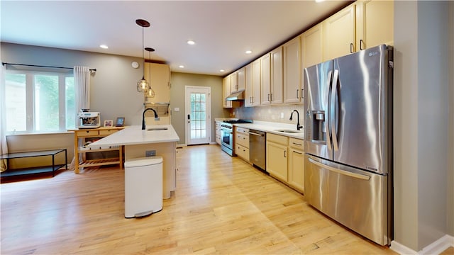5445 Covode Pl, Squirrel Hill, PA 15217 - kitchen with appliances with stainless steel finishes, under cabinet range hood, light wood-style floors, backsplash, and light countertops
