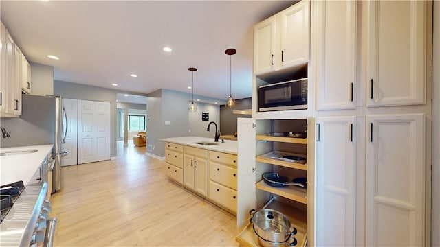 5445 Covode Pl, Squirrel Hill, PA 15217 - kitchen featuring black microwave, stainless steel stove, light wood-style floors, pendant lighting, and light countertops