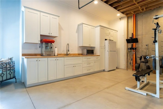 203 Ironwood Ct, Peters Twp, PA 15367 - kitchen featuring freestanding refrigerator, concrete floors, stainless steel microwave, ornamental molding, and white cabinets