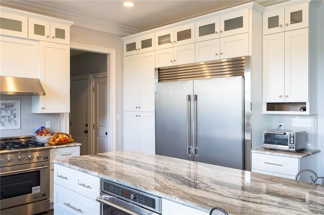 203 Ironwood Ct, Peters Twp, PA 15367 - kitchen featuring high end appliances, wall chimney range hood, light stone counters, white cabinetry, and tasteful backsplash