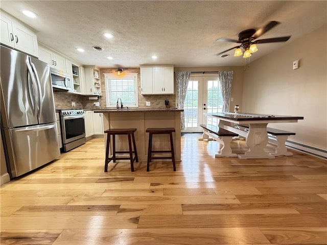 84 Williamson Rd, Hempfield Twp Mer, PA 16125 - kitchen featuring stainless steel appliances, a textured ceiling, light wood finished floors, white cabinets, and open shelves