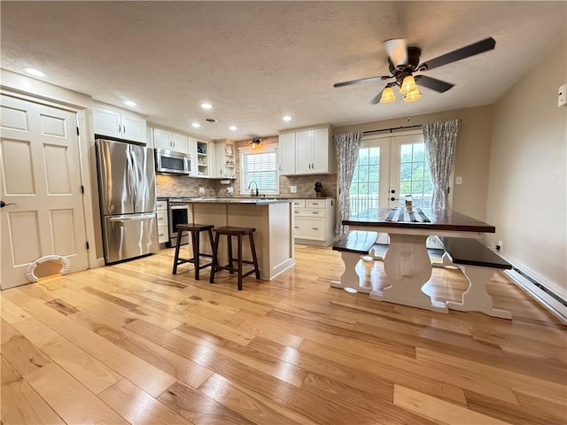 84 Williamson Rd, Hempfield Twp Mer, PA 16125 - kitchen with stainless steel appliances, light wood-style floors, a kitchen bar, a textured ceiling, and white cabinets