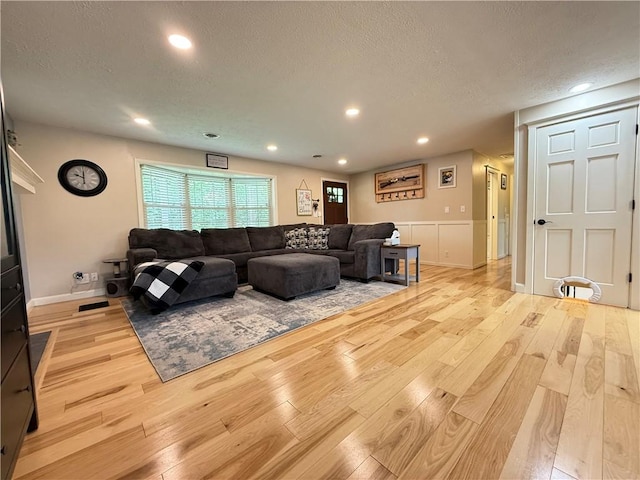 84 Williamson Rd, Hempfield Twp Mer, PA 16125 - living room with wood finished floors, a textured ceiling, wainscoting, recessed lighting, and a decorative wall