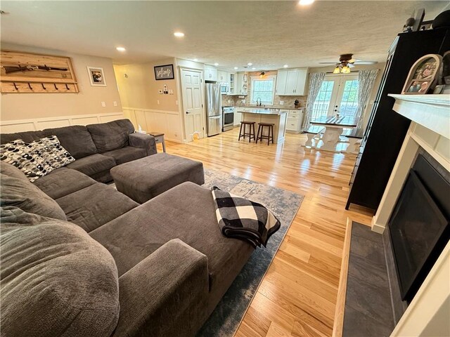 84 Williamson Rd, Hempfield Twp Mer, PA 16125 - living area with recessed lighting, a wainscoted wall, light wood-type flooring, a ceiling fan, and a fireplace with flush hearth
