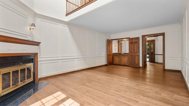 105 Bristol Sq, Ohara, PA 15238 - unfurnished living room with a decorative wall, a fireplace, and light wood-style floors