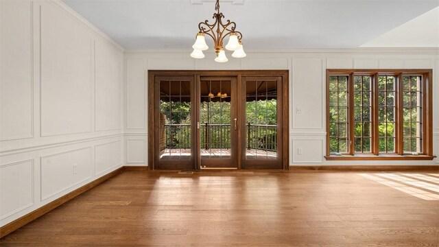 105 Bristol Sq, Ohara, PA 15238 - doorway to outside featuring a decorative wall, a chandelier, wood finished floors, and ornamental molding