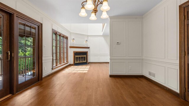 105 Bristol Sq, Ohara, PA 15238 - unfurnished living room featuring a decorative wall, a chandelier, wood finished floors, and a fireplace with flush hearth