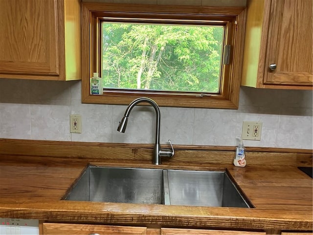 113 Filer Ln, Clay Twp, PA 16001 - kitchen view of dark countertops, decorative backsplash, and brown cabinetry