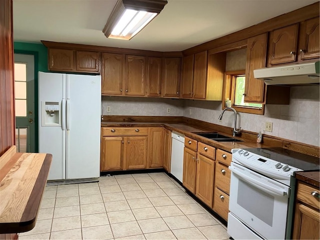 113 Filer Ln, Clay Twp, PA 16001 - kitchen featuring white appliances, under cabinet range hood, dark countertops, light tile patterned floors, and brown cabinets