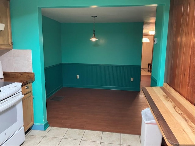 113 Filer Ln, Clay Twp, PA 16001 - kitchen with white electric range oven, light tile patterned flooring, hanging light fixtures, and dark countertops