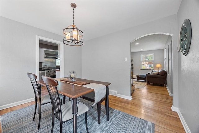 304 Fieldbrook Dr, Mt Lebanon, PA 15228 - dining room with arched walkways, light wood-style floors, and a chandelier