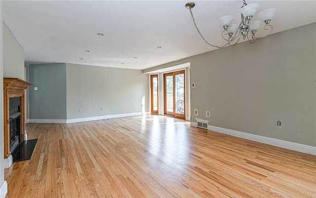 116 Parkfel Ave, Mccandless, PA 15237 - unfurnished living room with light wood-style flooring, a chandelier, and a fireplace with raised hearth