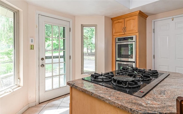 116 Parkfel Ave, Mccandless, PA 15237 - kitchen featuring black gas stovetop, stainless steel double oven, light brown cabinets, light tile patterned flooring, and light stone countertops