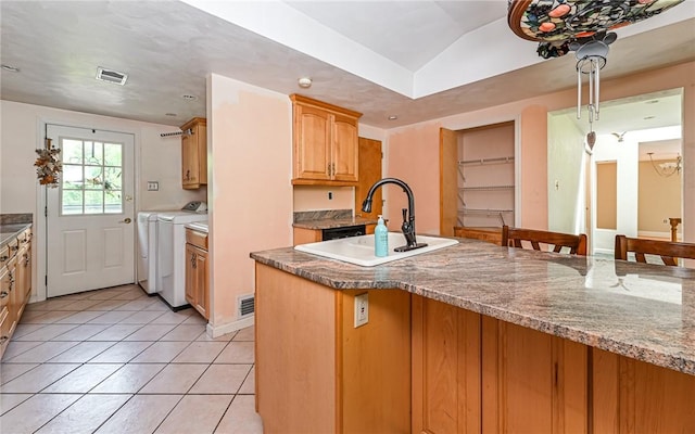 116 Parkfel Ave, Mccandless, PA 15237 - kitchen featuring washing machine and dryer, light tile patterned floors, stone countertops, and a kitchen bar