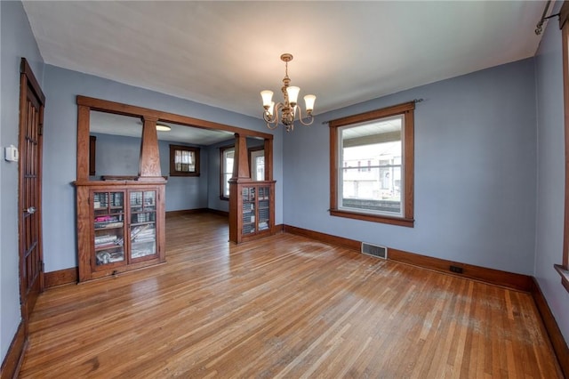438 Miami St, East Mckeesport, PA 15035 - empty room with light wood-type flooring and a chandelier