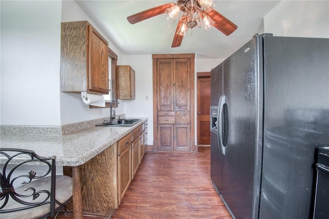 438 Miami St, East Mckeesport, PA 15035 - kitchen with black fridge with ice dispenser, wood finished floors, brown cabinets, ceiling fan, and a breakfast bar area