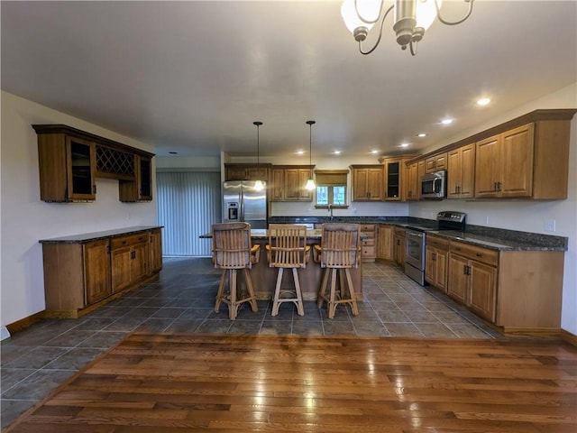 350 American Legion Rd, Unity Twp, PA 15650 - kitchen featuring stainless steel appliances, dark countertops, a kitchen island, glass insert cabinets, and a breakfast bar area