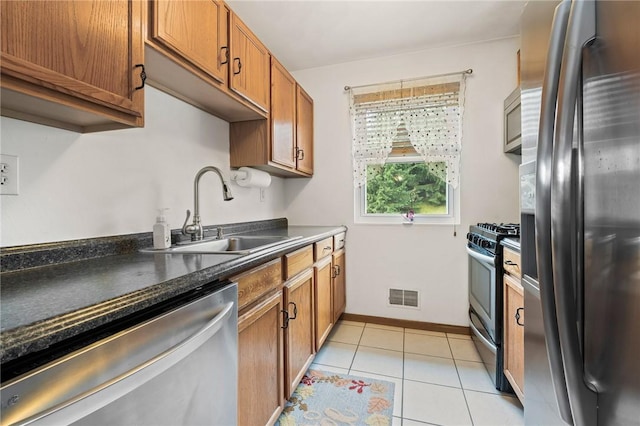 130 Pine Ct, Plum Boro, PA 15239 - kitchen featuring stainless steel appliances, brown cabinets, dark countertops, and light tile patterned floors