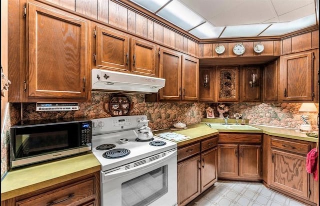334 E State St, Sharon, PA 16146 - kitchen featuring white electric range oven, extractor fan, black microwave, brown cabinetry, and light countertops