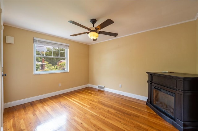 524 Saint Andrews Dr, Hempfield Twp Wml, PA 15601 - empty room with a glass covered fireplace, light wood finished floors, ceiling fan, and crown molding