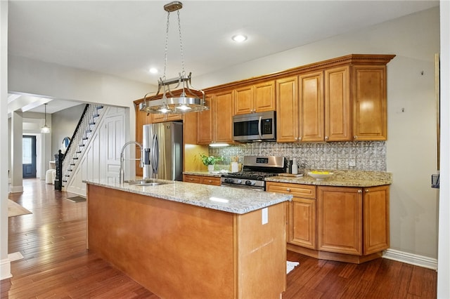 2315 Jane St, South Side, PA 15203 - kitchen with stainless steel appliances, a kitchen island with sink, dark wood-style floors, tasteful backsplash, and light stone counters