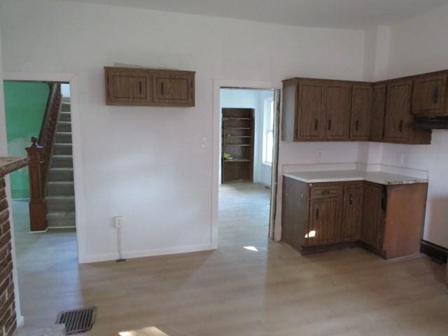 1250 Summerlea Ave, City Of Washington, PA 15301 - kitchen featuring light wood-type flooring, light countertops, brown cabinetry, and under cabinet range hood