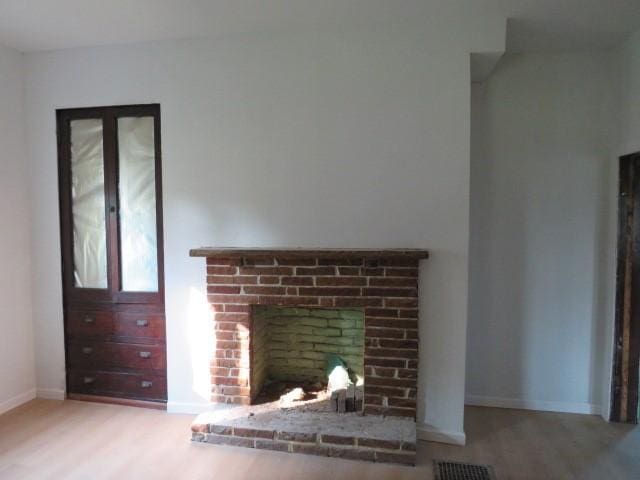 1250 Summerlea Ave, City Of Washington, PA 15301 - unfurnished living room featuring a brick fireplace and wood finished floors