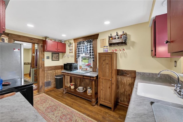 914 E Smithfield St, Elizabeth Twp/Boro, PA 15135 - kitchen featuring black microwave, wainscoting, freestanding refrigerator, light wood-type flooring, and light countertops