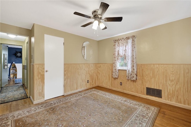 914 E Smithfield St, Elizabeth Twp/Boro, PA 15135 - empty room with wood finished floors, wainscoting, and a ceiling fan