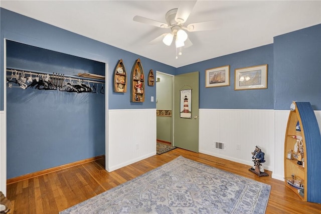 914 E Smithfield St, Elizabeth Twp/Boro, PA 15135 - bedroom with a wainscoted wall, wood finished floors, a ceiling fan, and a closet