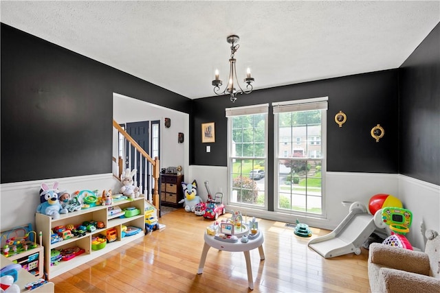 317 Shady Glen Dr, Moon/Crescent Twp, PA 15108 - playroom with wainscoting, a chandelier, wood finished floors, and a textured ceiling